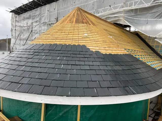 Half-slated conical roof, with slates laid round the curve