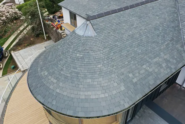 Curved natural slate roof with a lead cone at the top