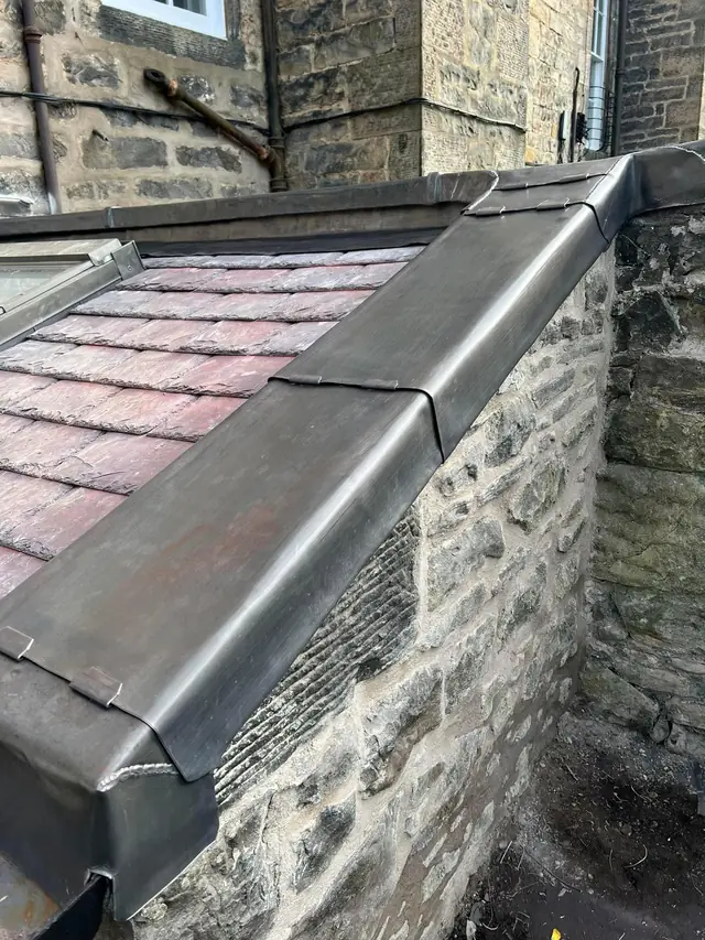 Lead capping and flashing along a stone wall