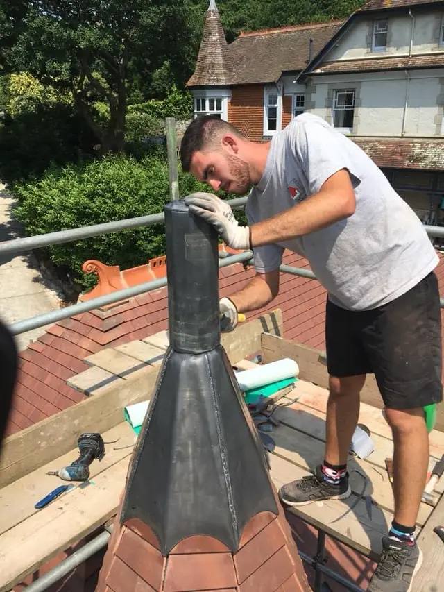 Dressing a hand-made lead finial on top of a tiled turret