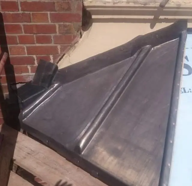 Hand-dressed lead flashing against a brick wall