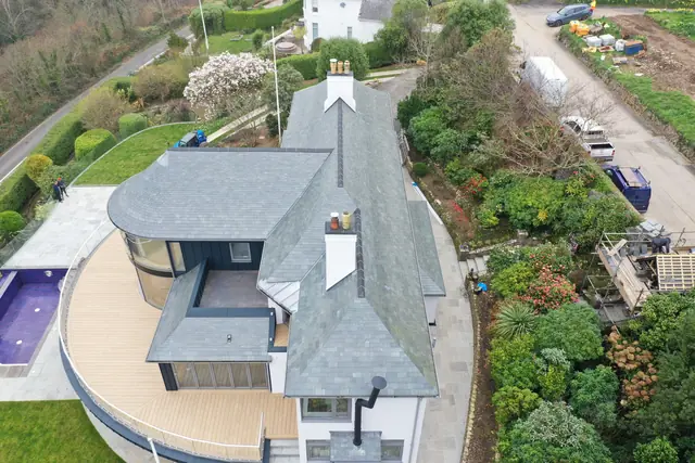 Overhead drone view of a large house roofed in natural slate