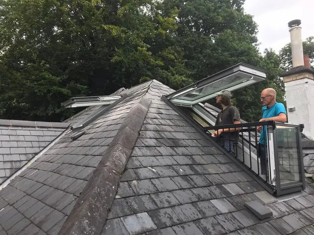 Open VELUX Cabrio balcony windows on a natural slate hip roof