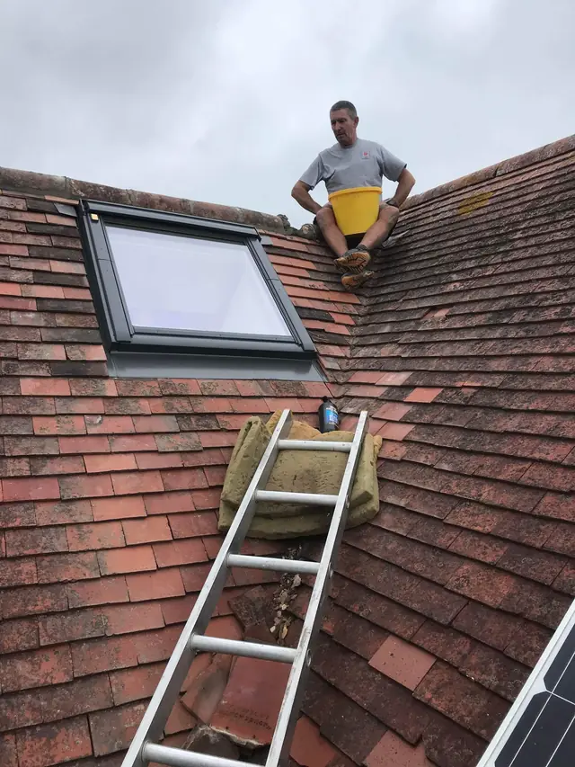 New VELUX roof window on a clay tile roof, with one of the team on the ridge