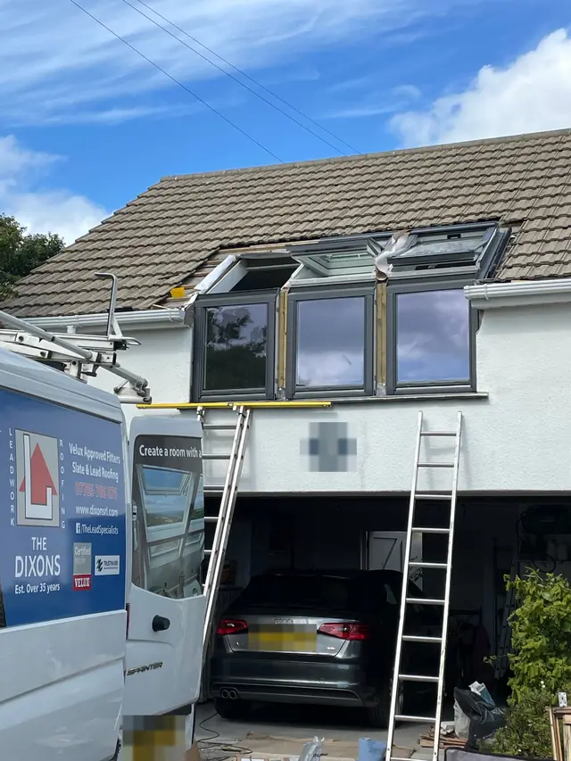 New VELUX windows above a dormer, with The Dixons van on the drive