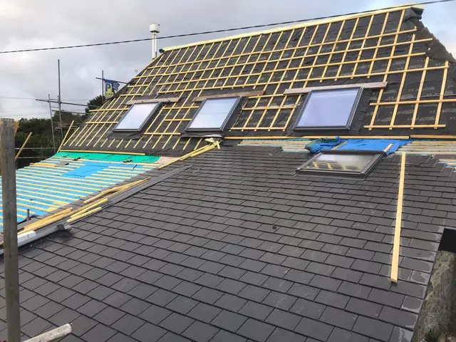 Three new VELUX roof windows going in during a slate re-roof